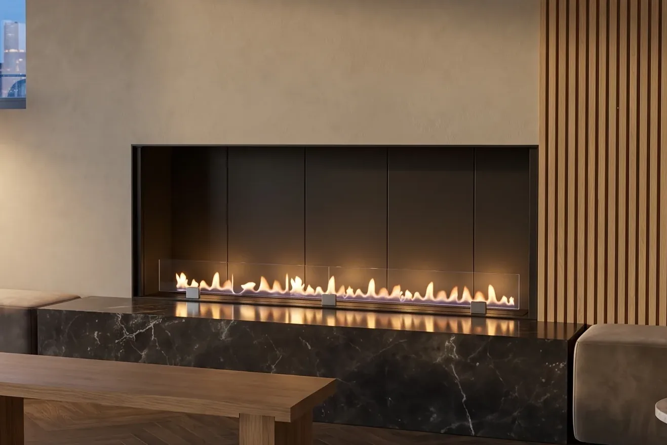 Llama de bioetanol que nace del quemador de una chimenea Fuegolo, en un interior minimalista